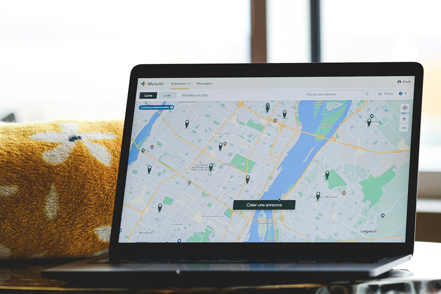Laptop screen displays a map with location pins and UI elements.